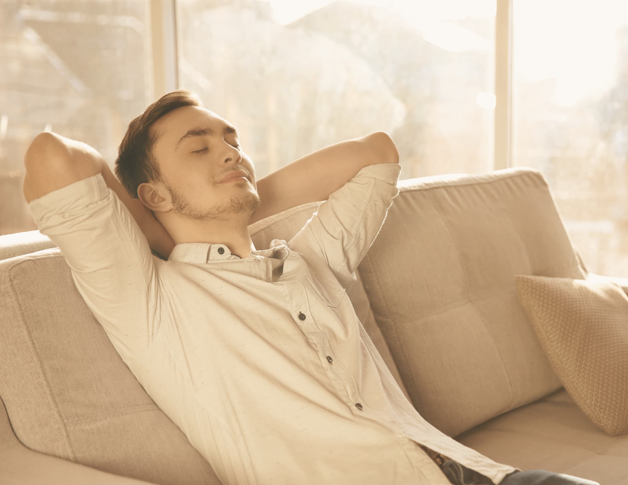 Man zit ontspannen op de bank met gesloten ogen, rust en ontspanning na doorbreken van een verslaving