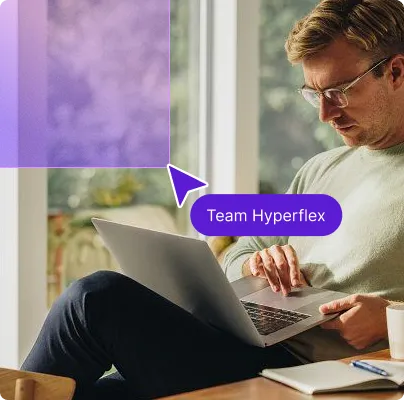 Man with glasses using a laptop at a table, labeled with a purple pointer saying Team Hyperflex.