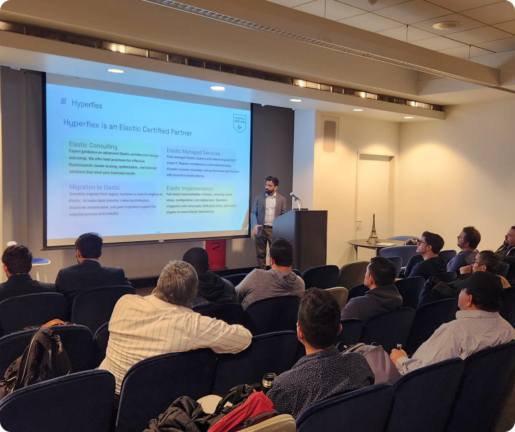 Man in suit giving presentation about Hyperflex as an Elastic Certified Partner to seated audience.