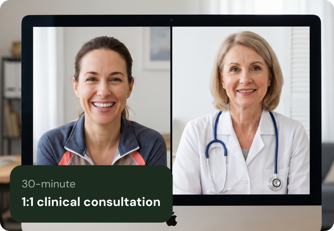 Female doctor wearing a white coat and stethoscope smiling and waving during a video call on a laptop.