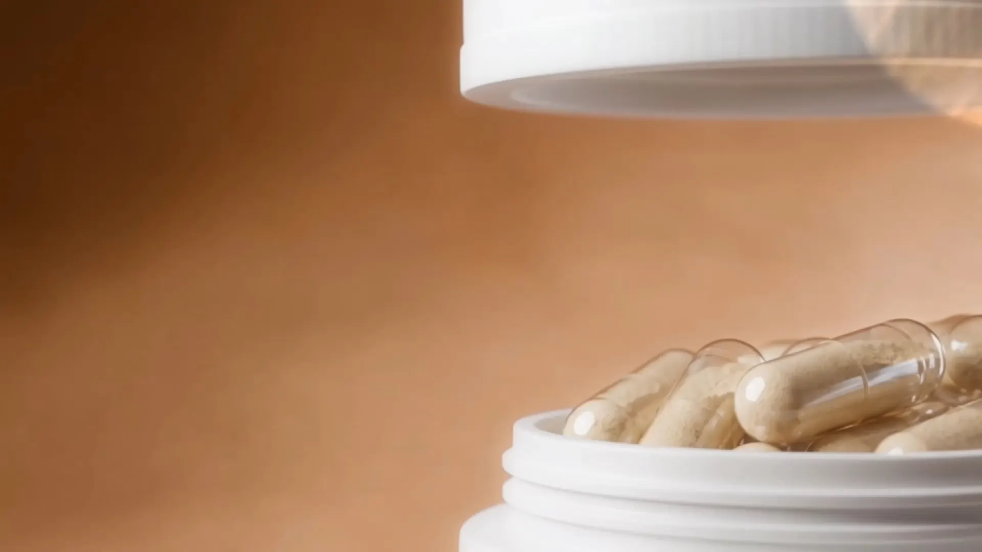 Open supplement jar filled with capsules, lid lifted, on a warm tan background