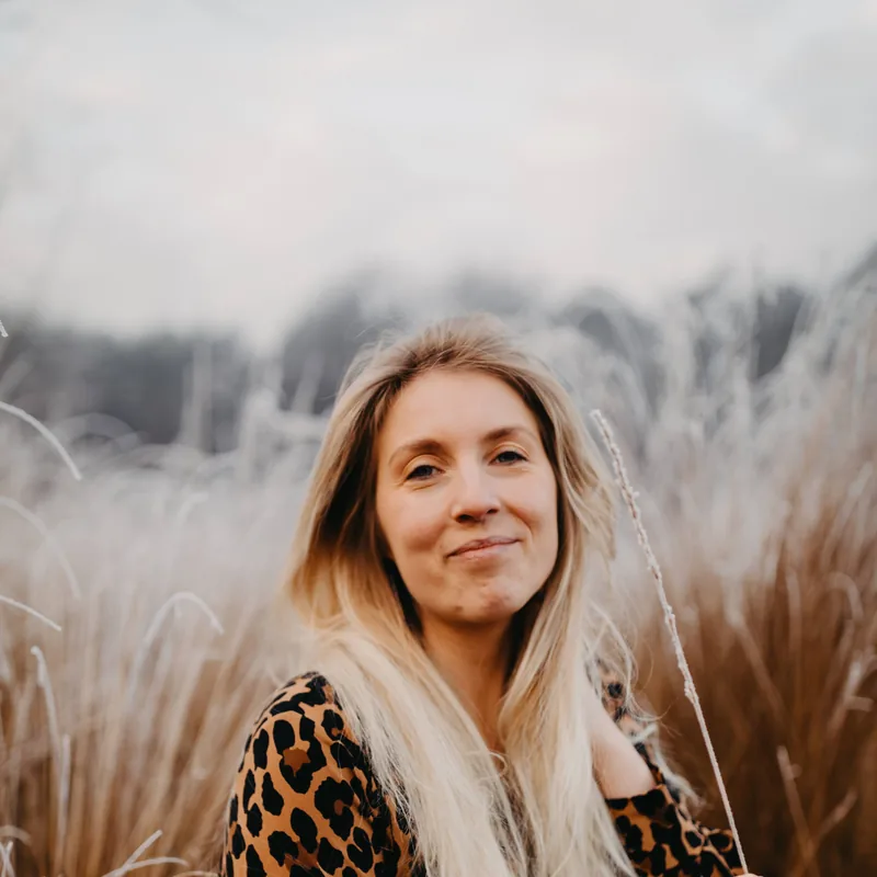 Shannen Rasking glimlacht zacht, zittend in het gras