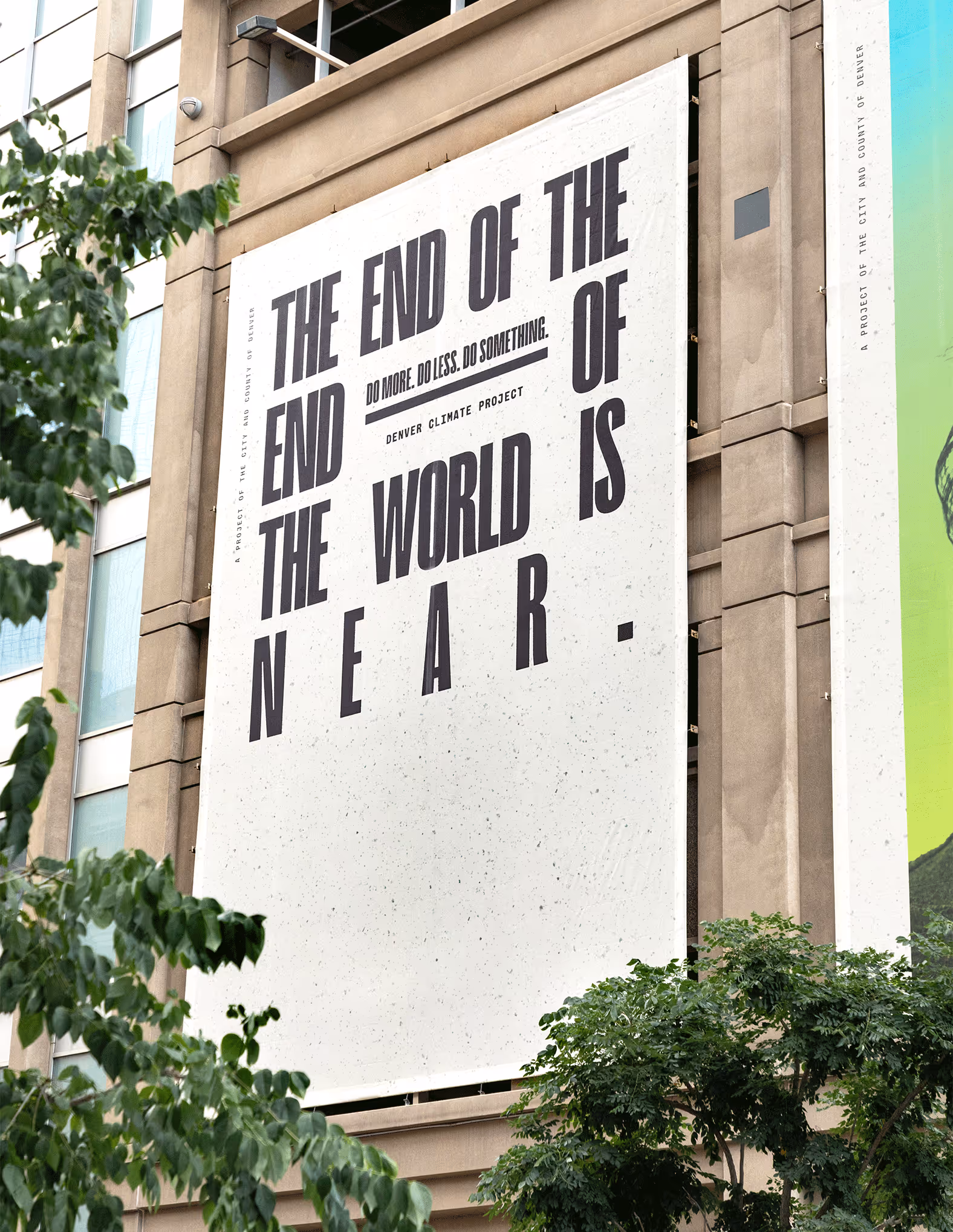 photo of a large vertical city billboard that reads "the end of the end of the world is near." Denver Climate Project.