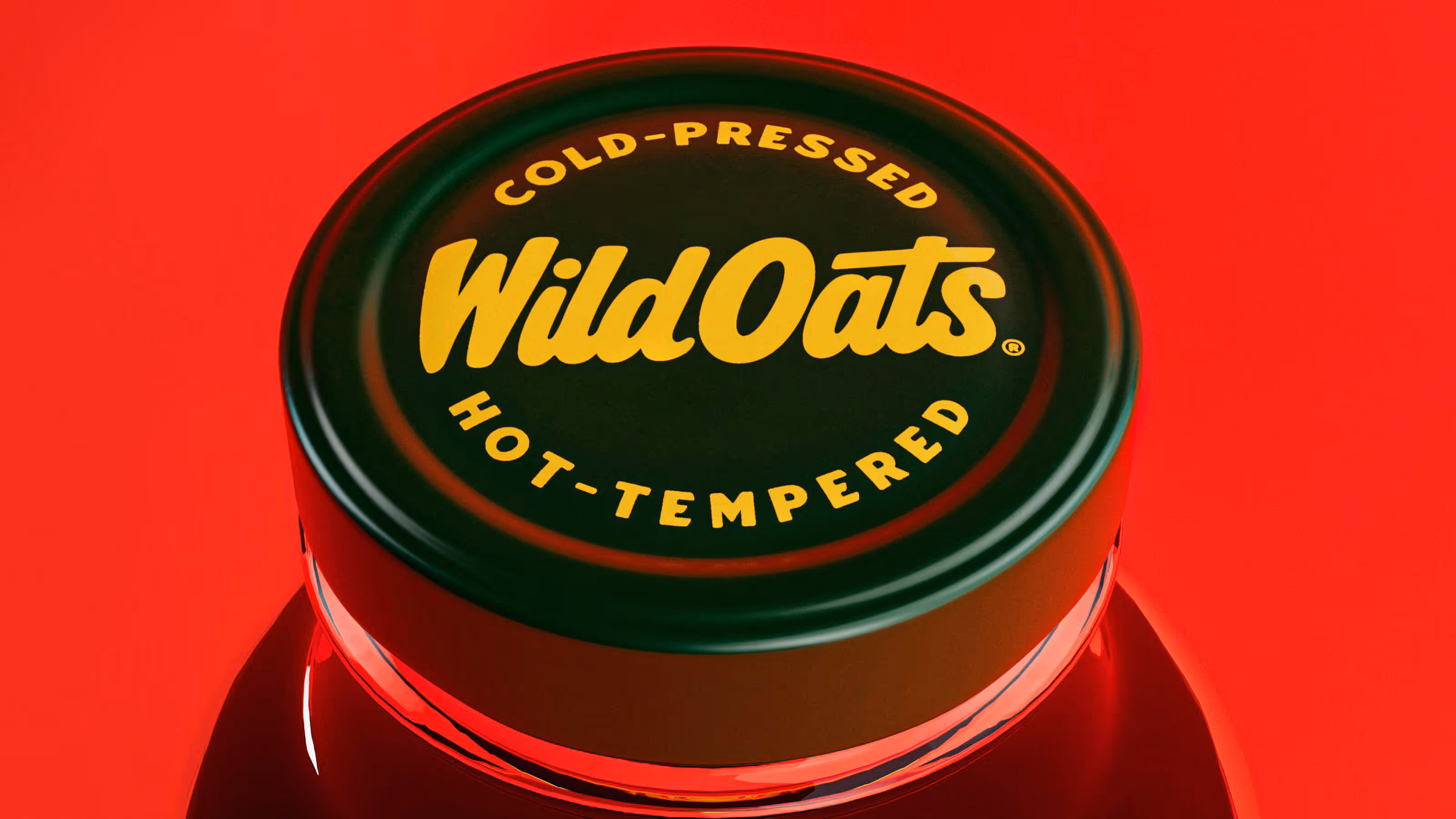 Close-up of a dark green bottle cap with yellow text reading 'Cold-Pressed Wild Oats Hot-Tempered' on a red background.