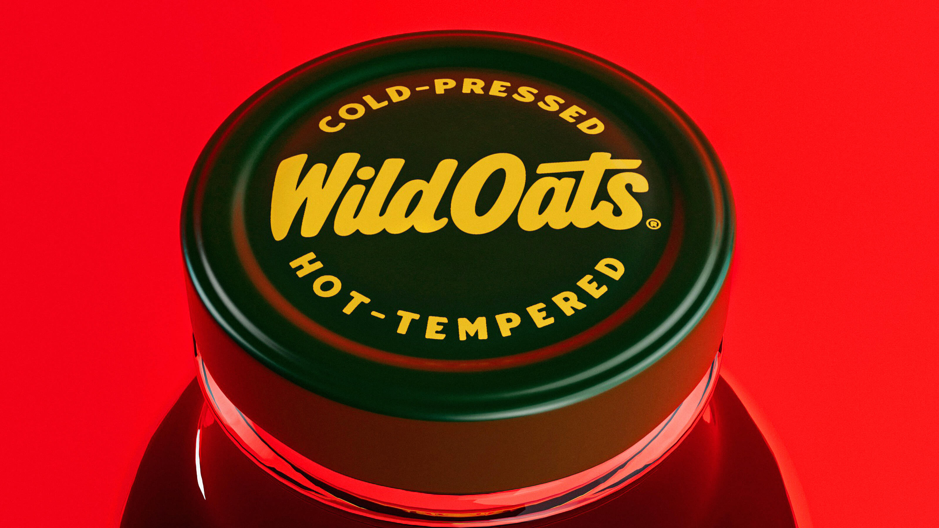 Close-up of a dark green bottle cap with yellow text reading 'Cold-Pressed Wild Oats Hot-Tempered' on a red background.
