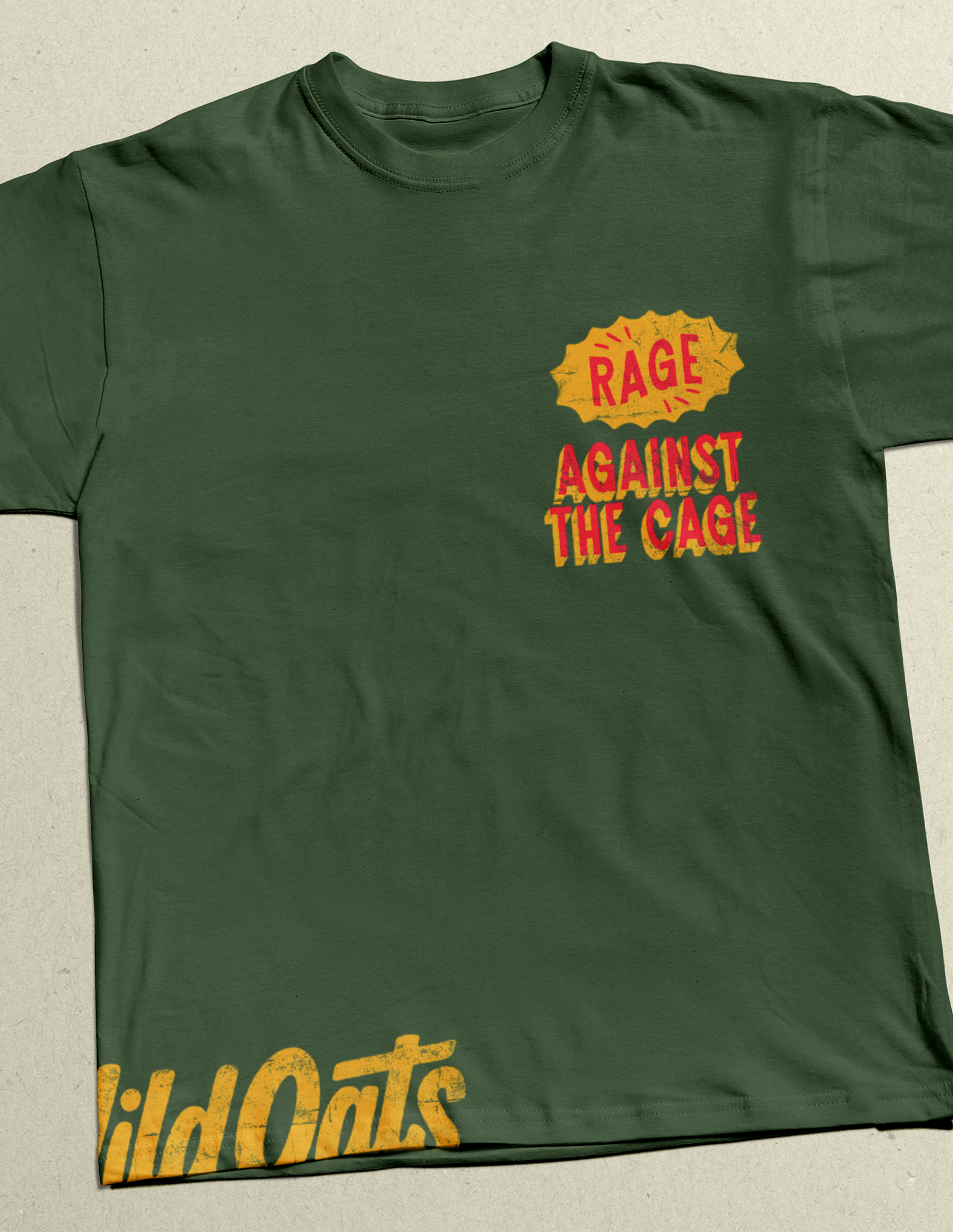 Green t-shirt with red and yellow text reading 'Rage Against The Cage' on the front pocket area and 'Wild Oats' partially visible at the bottom.