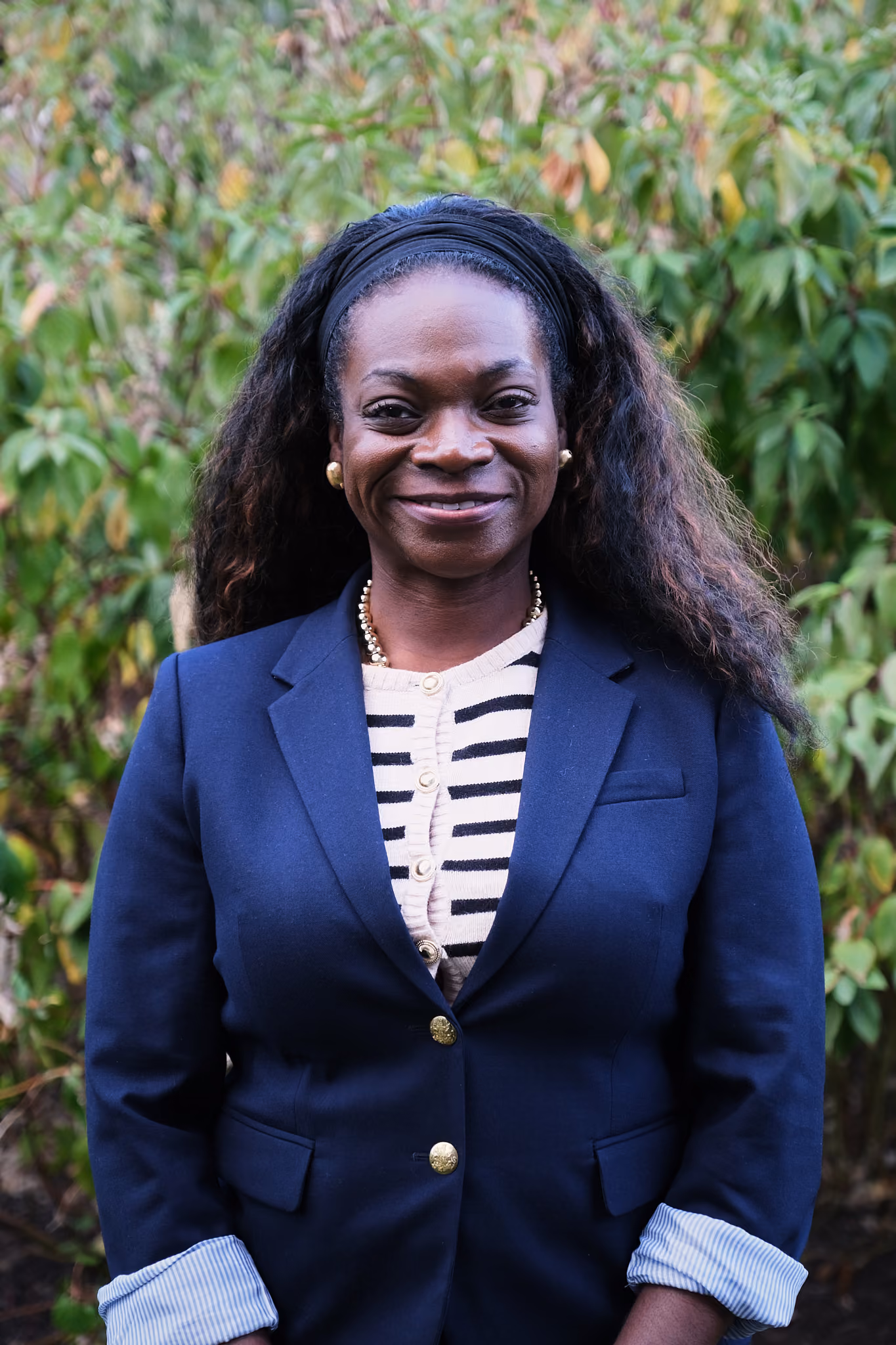 Gigi Darko smiling outdoors in a navy blazer