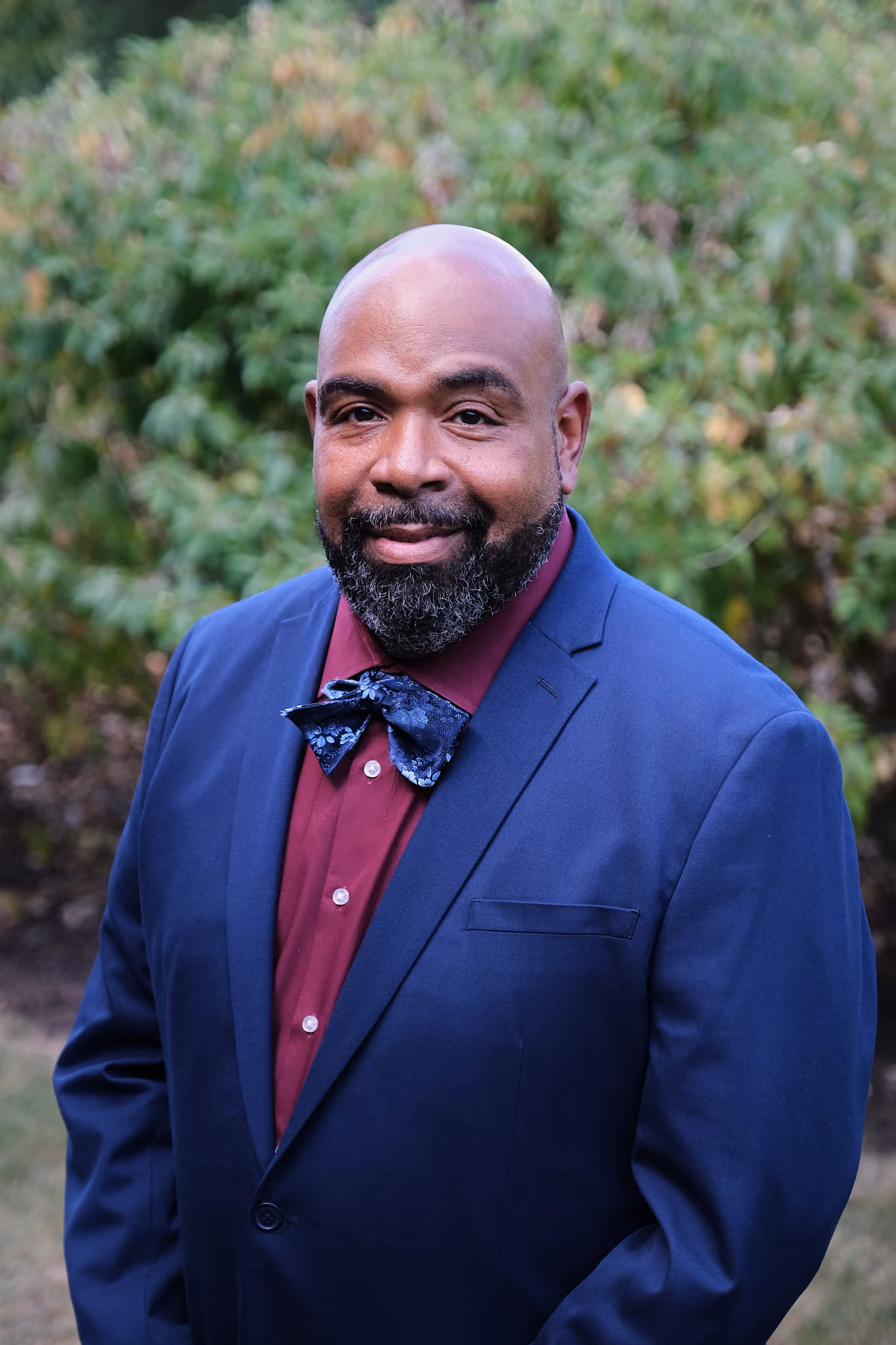 Jason Rivers staff portrait in blue blazer and bow tie