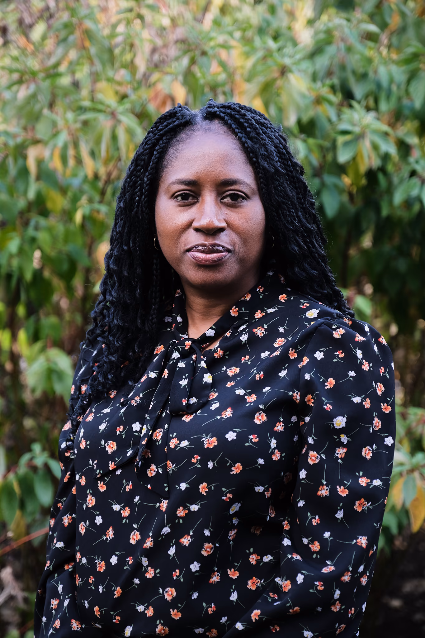 Staff portrait of Laura Onwuka outdoors with green foliage background