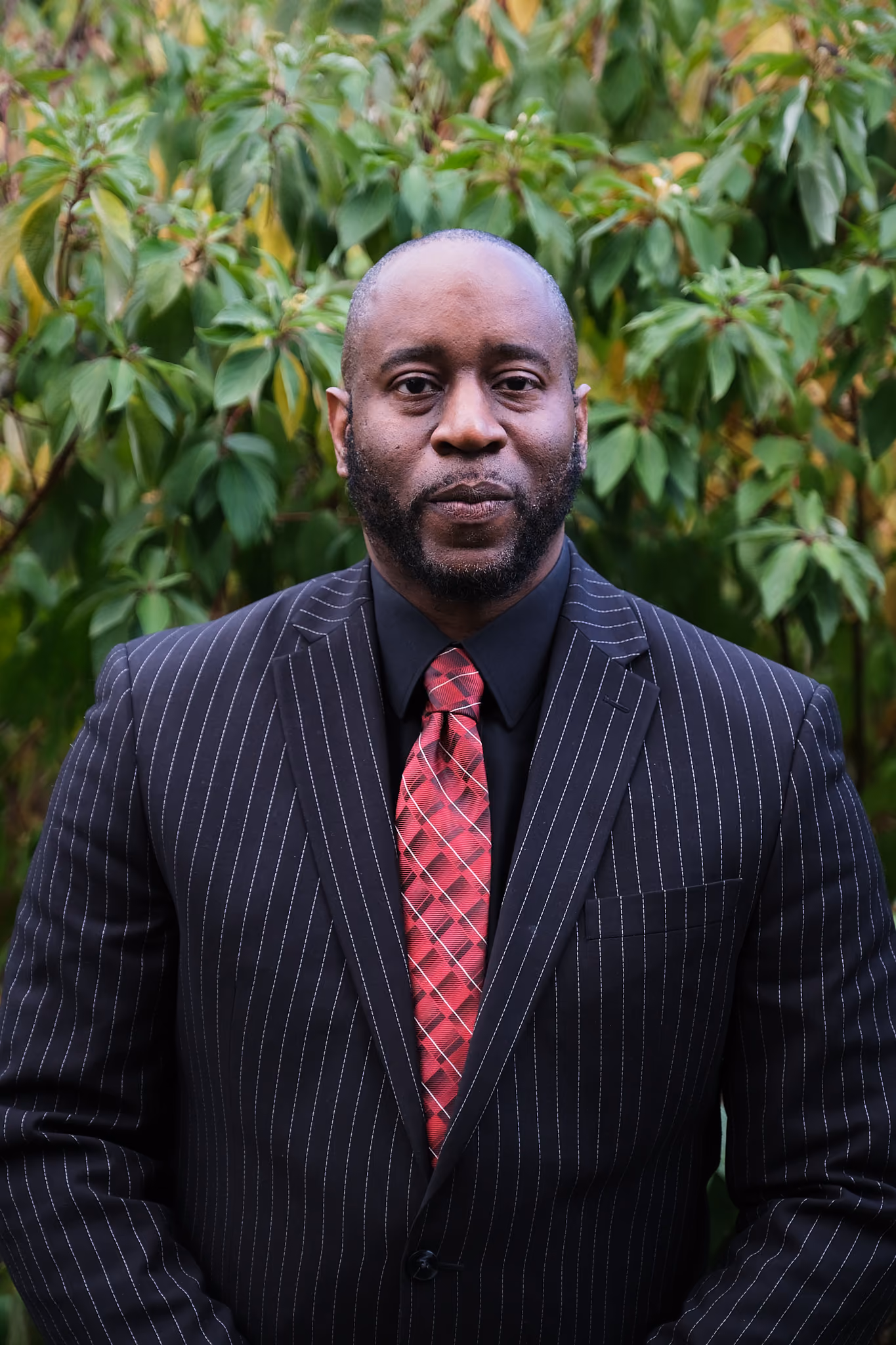 Cahnlay Moore in a pinstripe suit and red tie outdoors