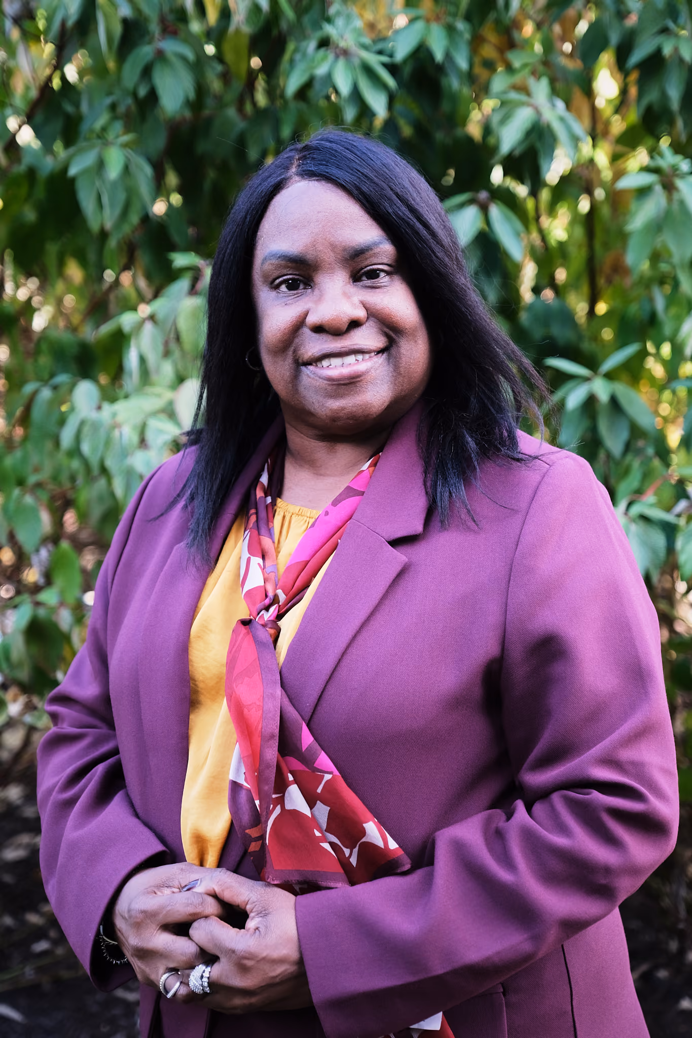 Linda L. Harris smiling outdoors in a purple blazer