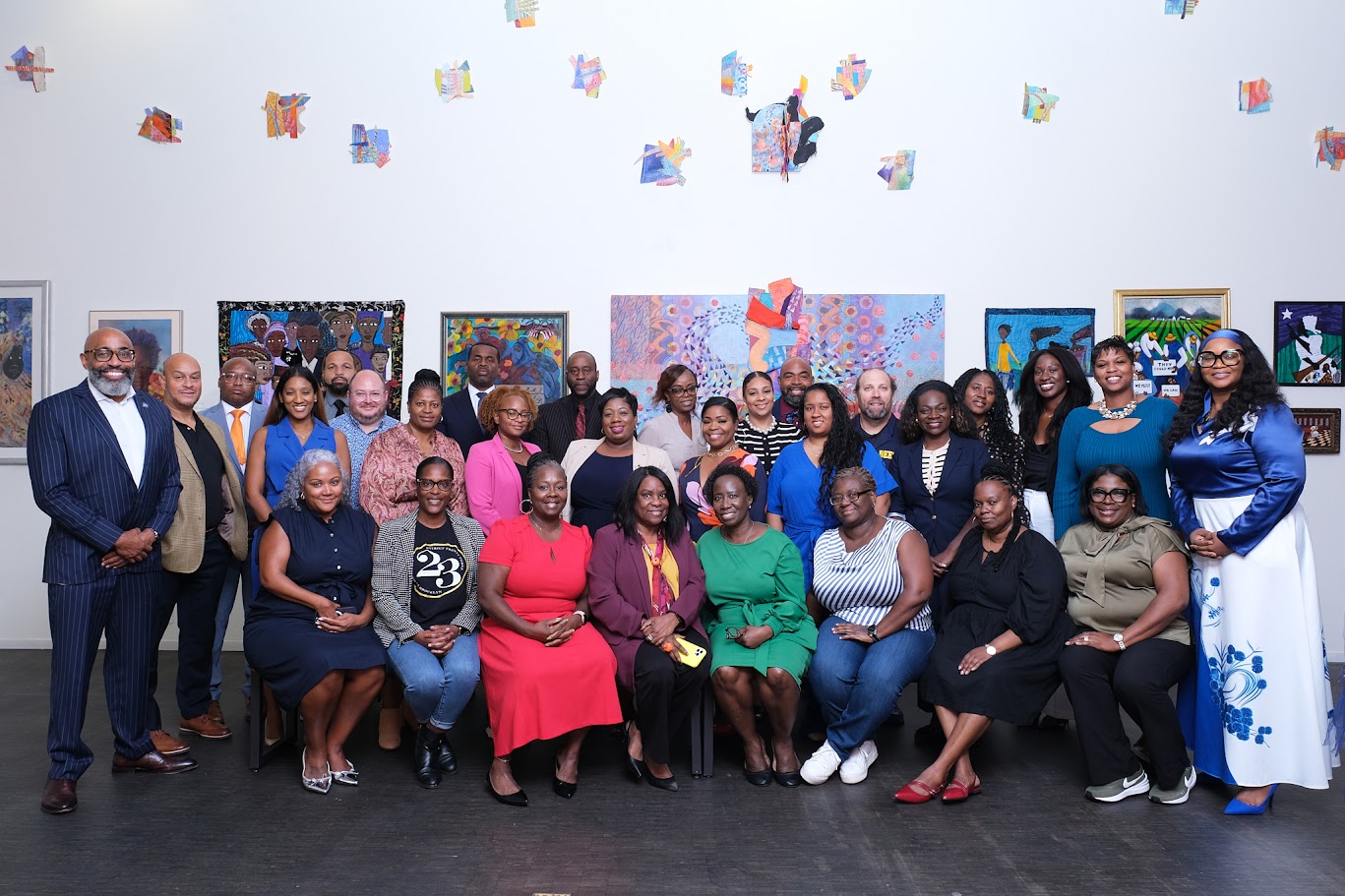 Large group of educators posing together inside a colorful art gallery