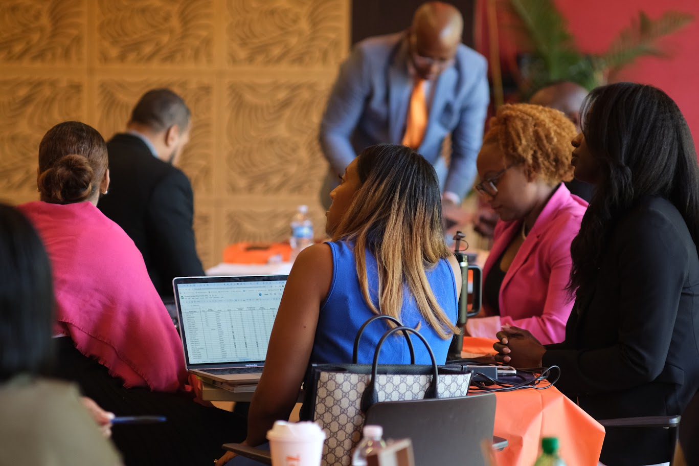 Educators collaborating at tables with laptops during a professional workshop