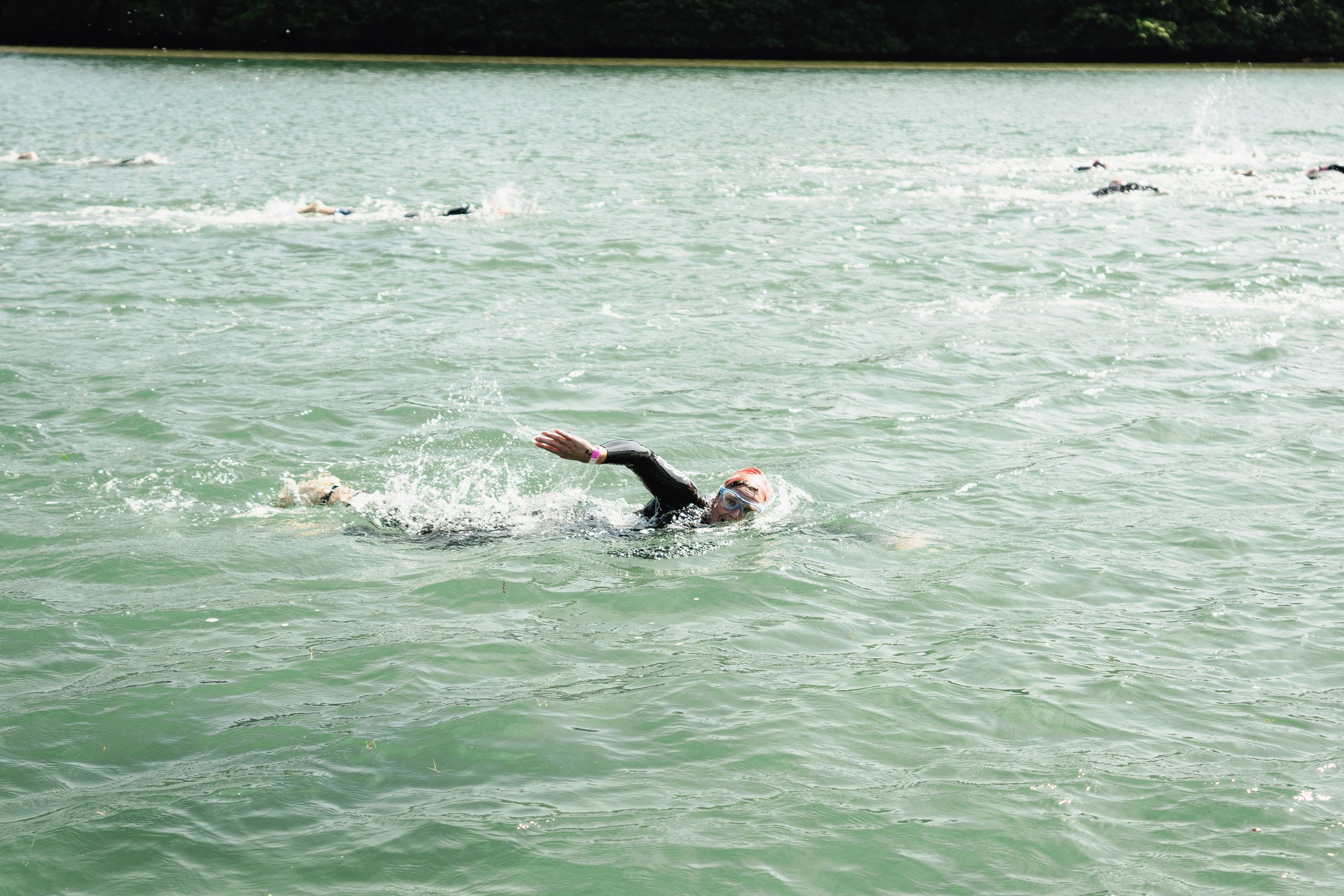 Three swimmers smiling at start of a Chillswim event