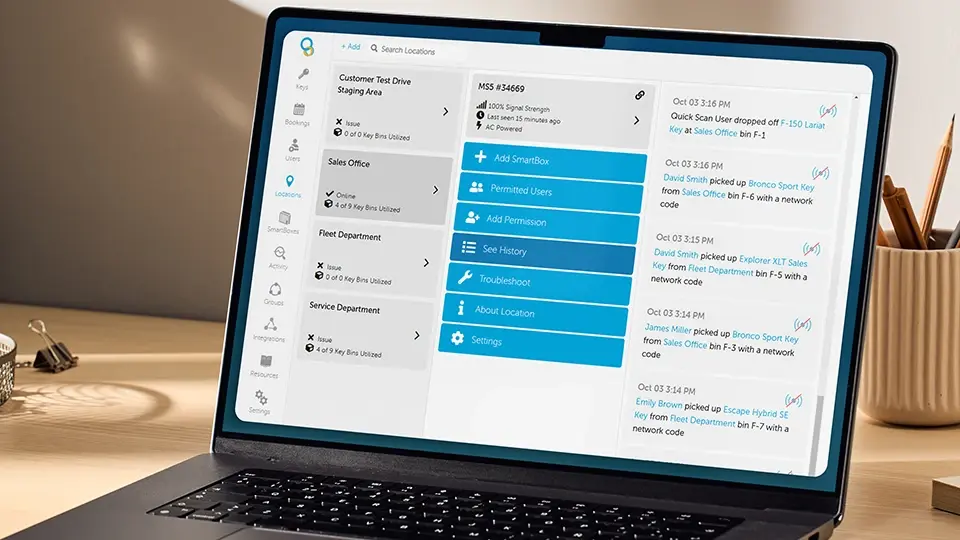 Laptop on desk displaying key management software with location statuses, user actions, and settings menu.