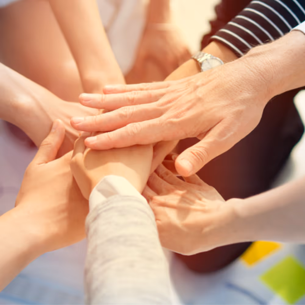 A team putting hands in the middle as a group