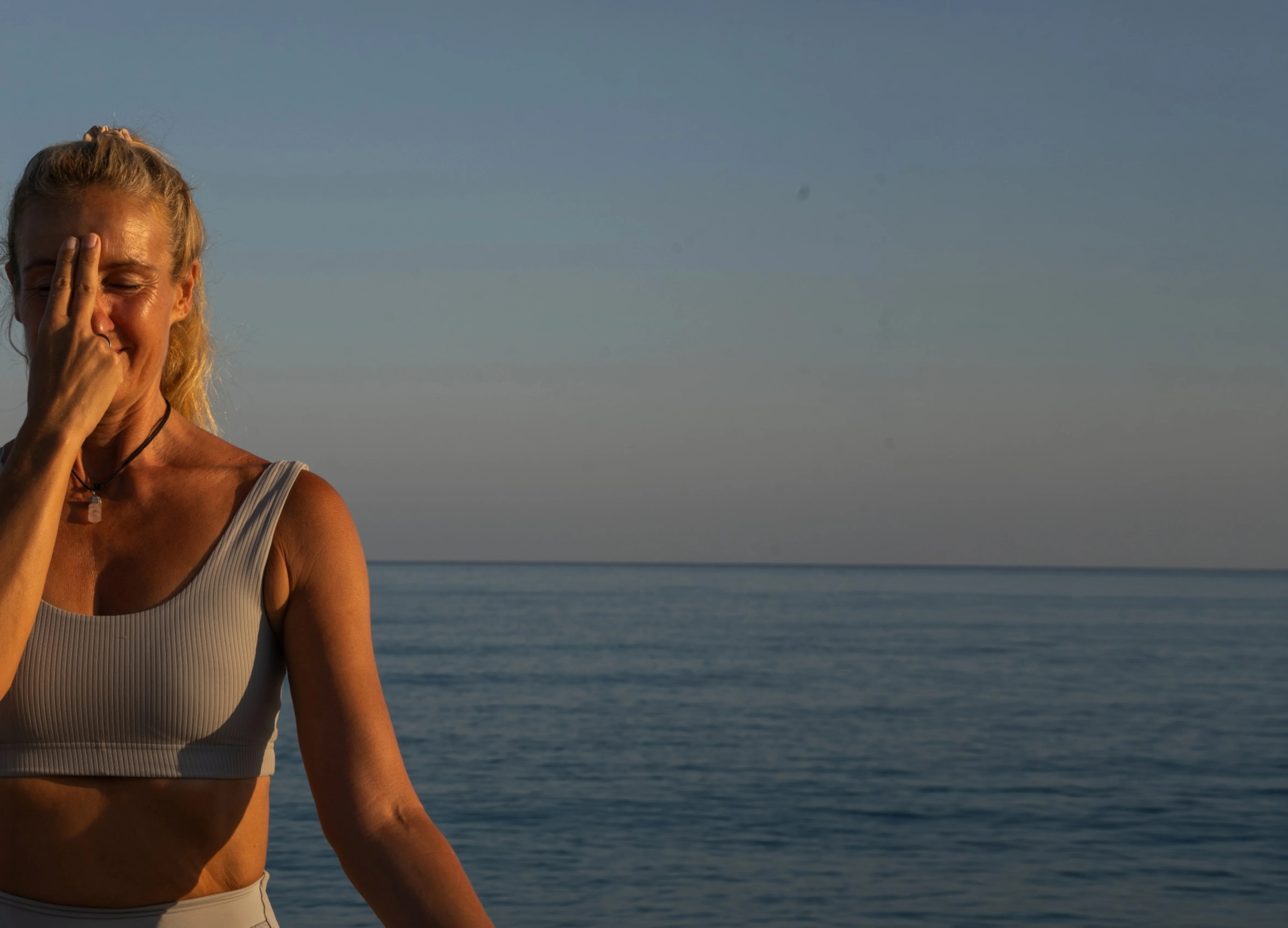 Patricia Römpke bei einer Atemübung am Meer im Sonnenuntergang auf Zypern – Blogartikel: Pranayama Atemtechniken