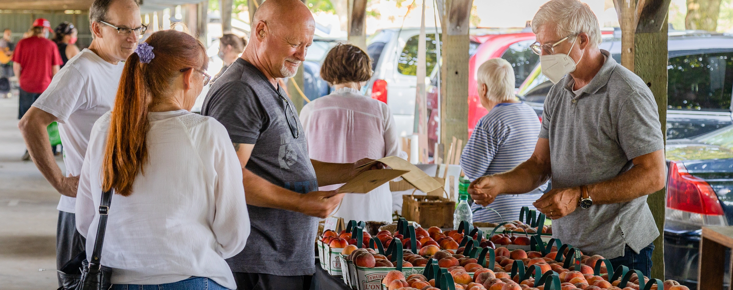 Patrons purchasing peaches from a vendor representing Wainfleet Farmers' Market