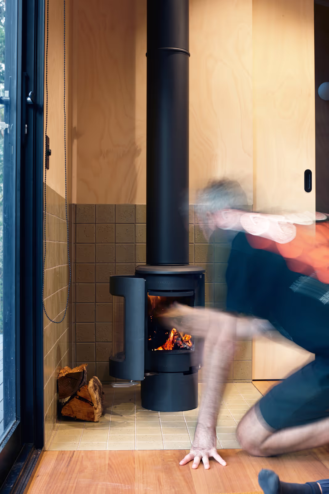 tall tiny house off-grid fireplace with a person in front of it