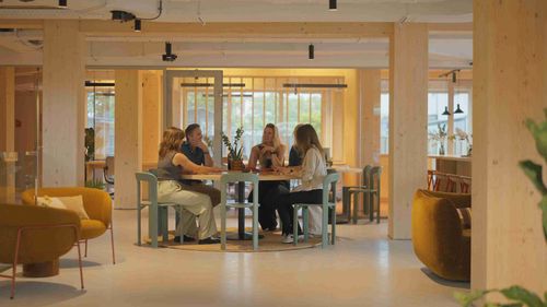 Gedeelde werkruimte in The Urban Woods Delft waar bewoners werken, ontmoeten en kennis delen binnen een duurzame community.