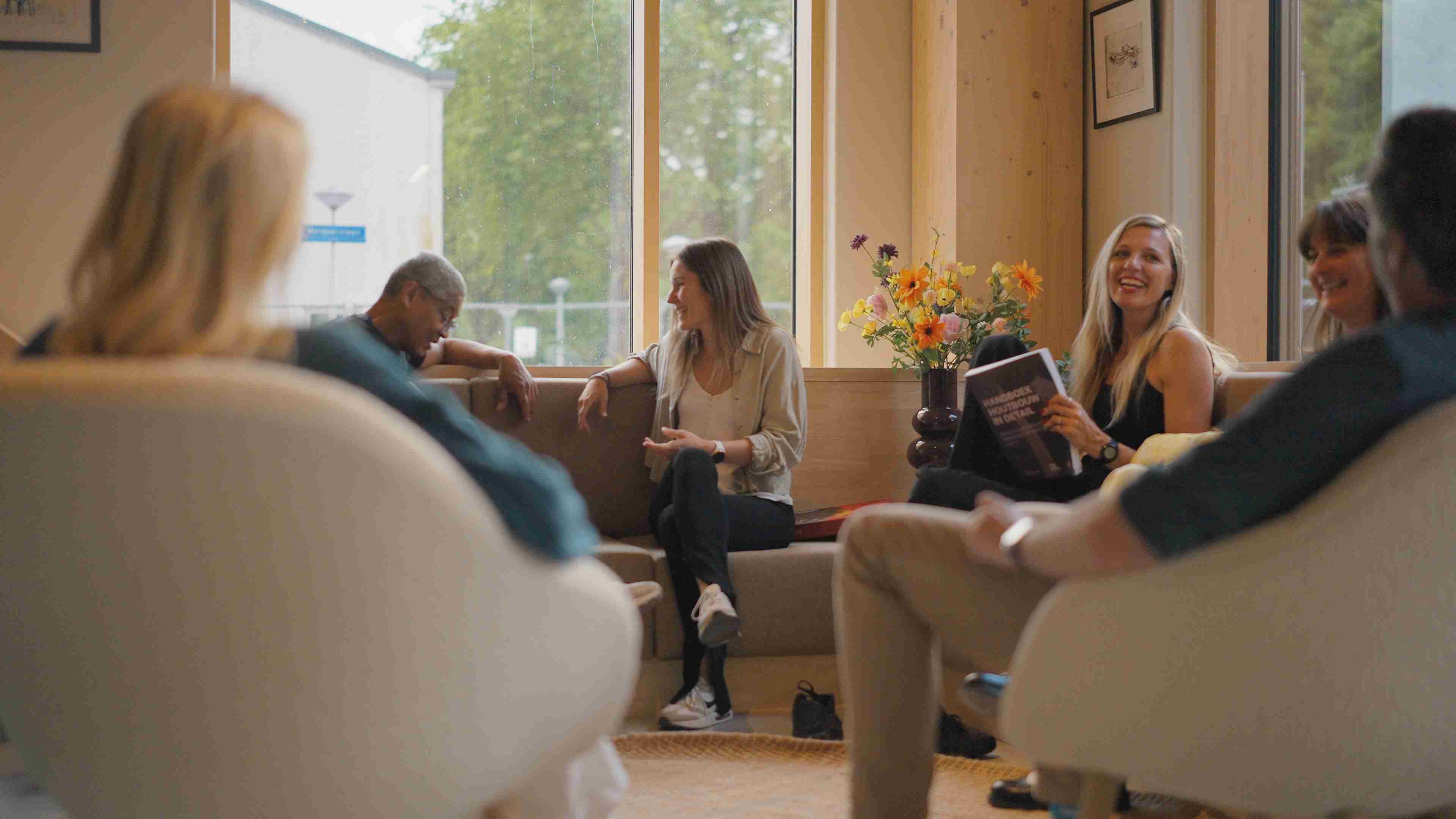 Residents gathering in the communal lounge at The Urban Woods Delft, designed to encourage connection and wellbeing..