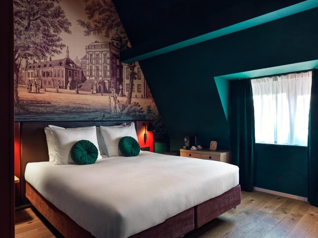 Sfeervolle hotelkamer van Hotel Fluwelen Burgwal in Den Haag met historische wanddecoratie en donkergroen interieur