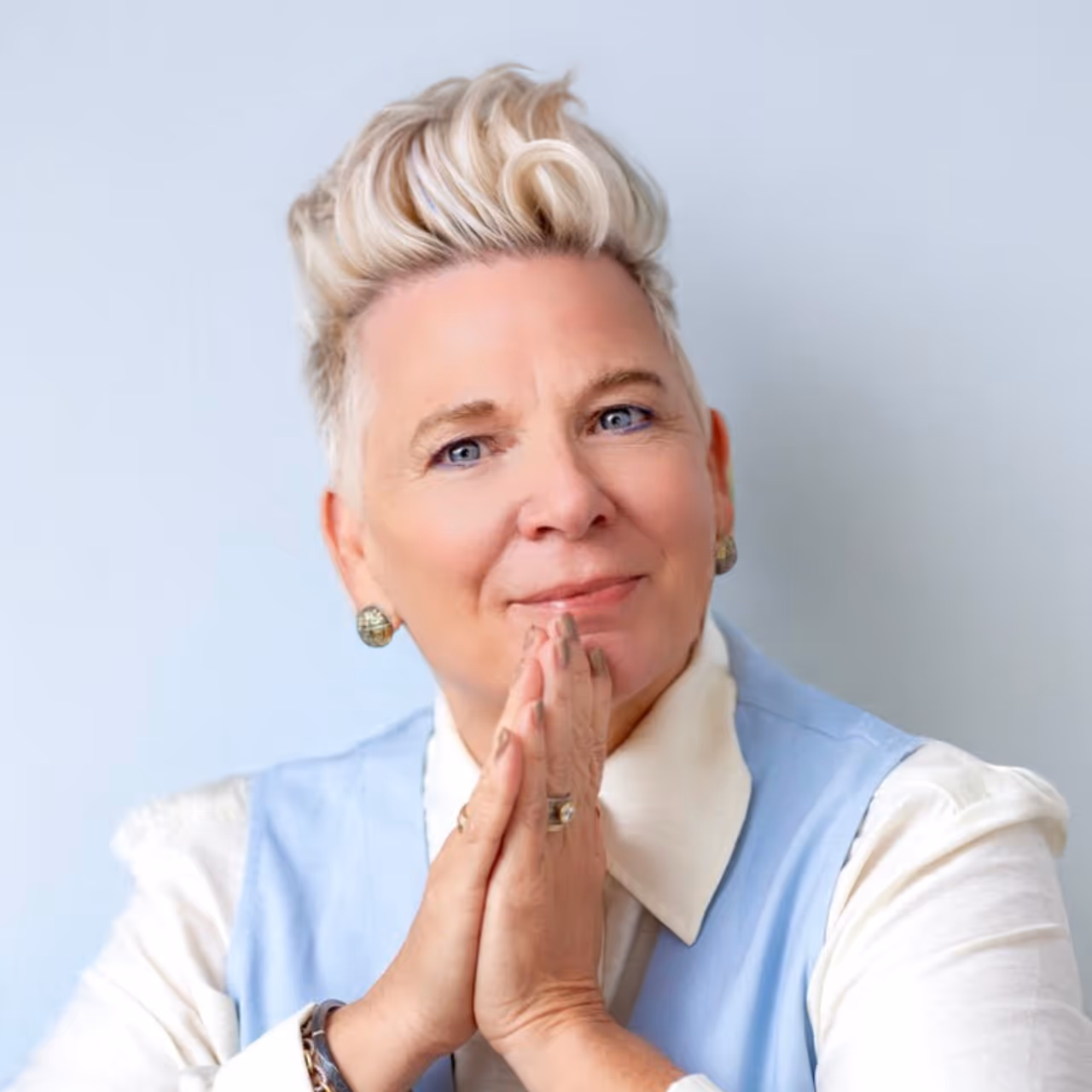 Female professor and friendship expert Dr. Kimberly Horn smiles while holding her hands in an inviting prayer pose.