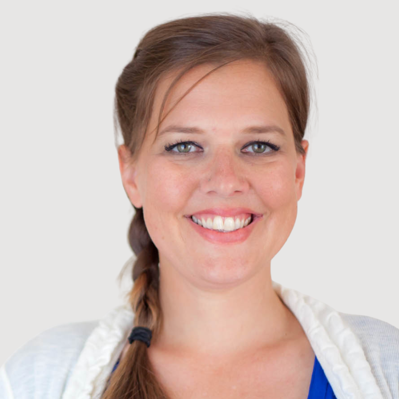 Professional headshot of female therapist Nikolai Blinow with strawberry blond braided hair wearing yoga attire.