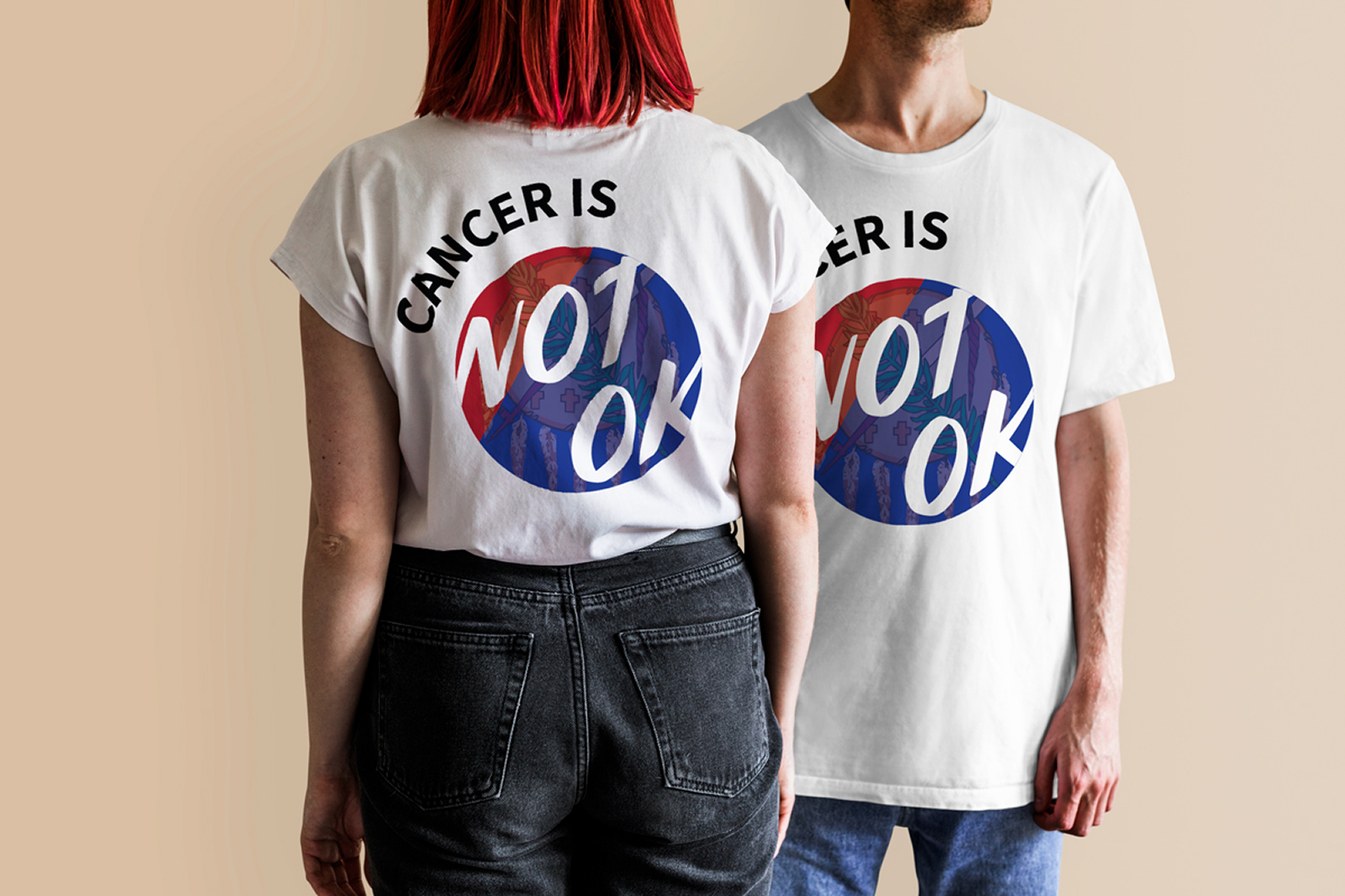 Man and woman wearing white shirts with Cancer Is Not Ok graphic in red and blue circle.