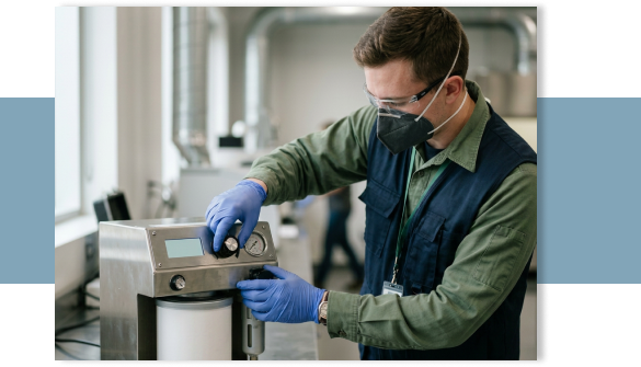 Mann hantiert an einem elektronischen Gerät und trägt eine Schutzmaske