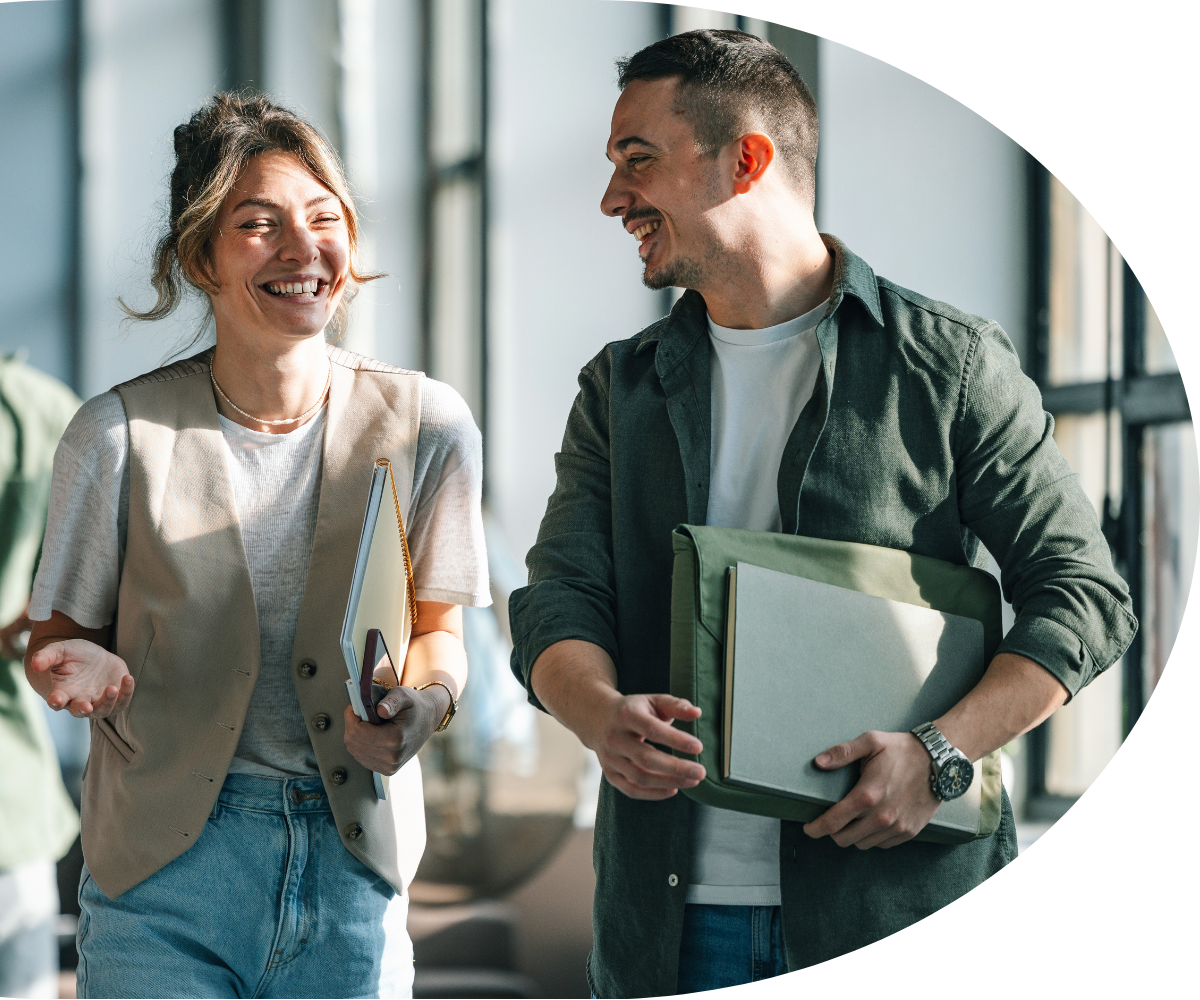 Professionals intently listening at a conference, taking notes on notepads