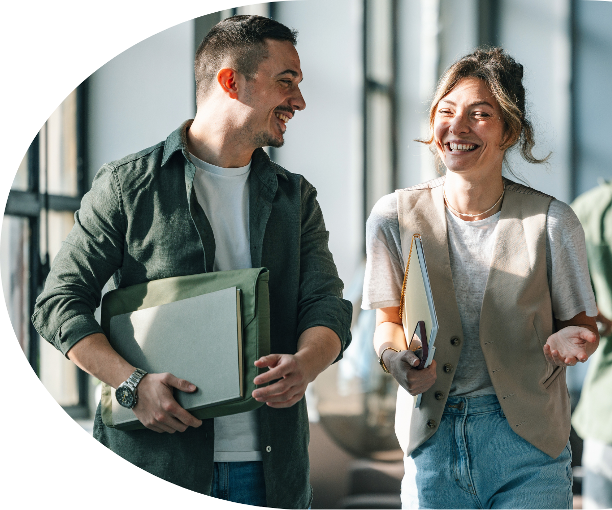 Professionals intently listening at a conference, taking notes on notepads