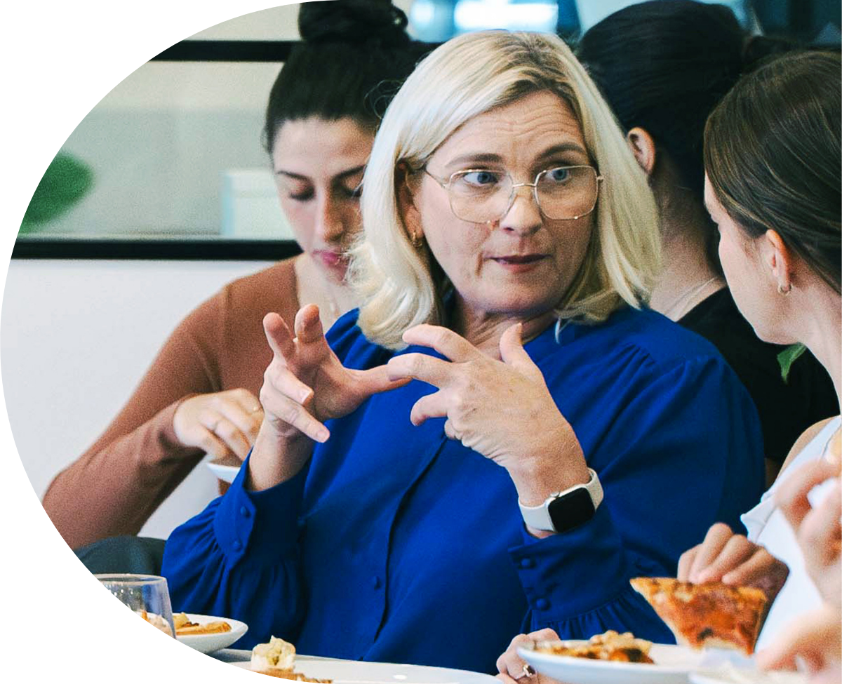 Professionals intently listening at a conference, taking notes on notepads
