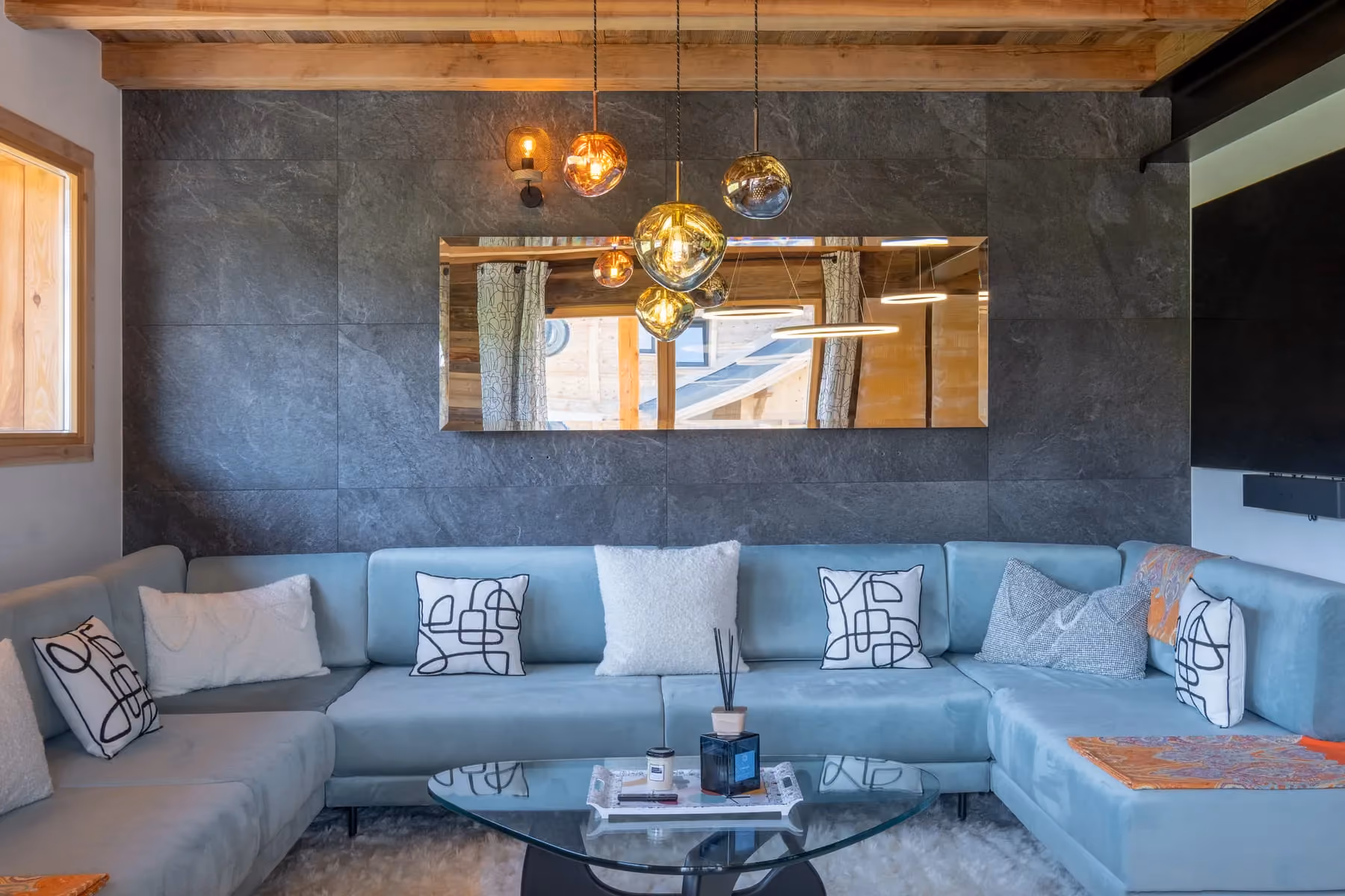 Spacious contemporary living room at Chalet Ango with panoramic sofa, between Combloux and Megève.