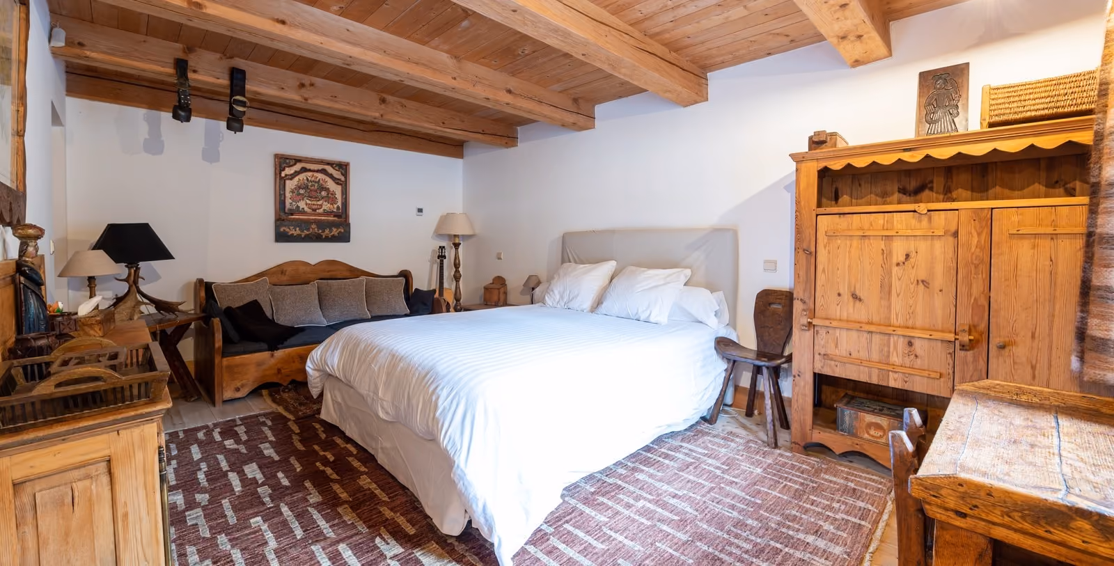Chambre double chaleureuse avec mobilier en bois massif dans un chalet de montagne à Megève.