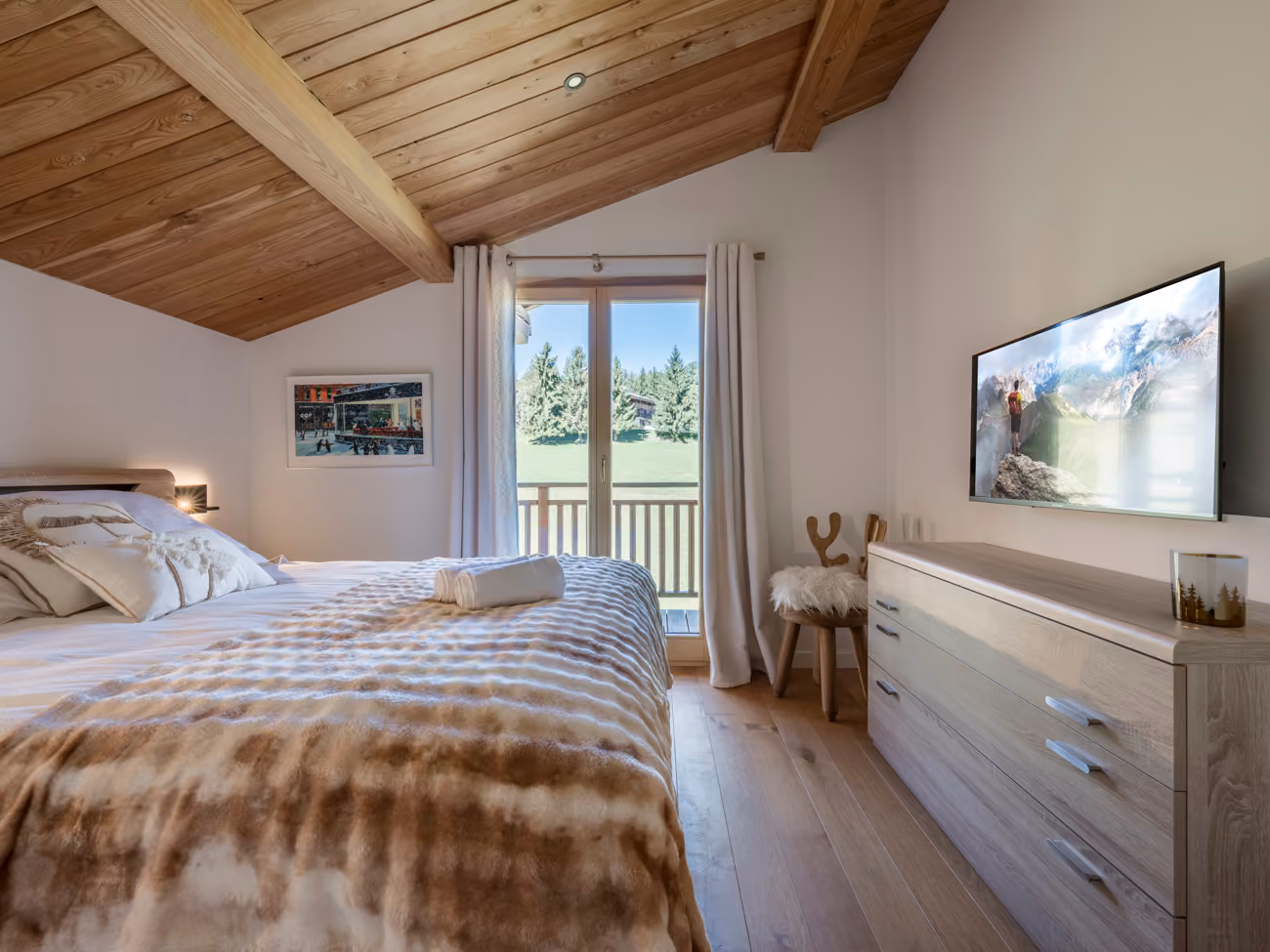 Comfortable bedroom with a private balcony and peaceful nature views at Chalet Zazen in Combloux.