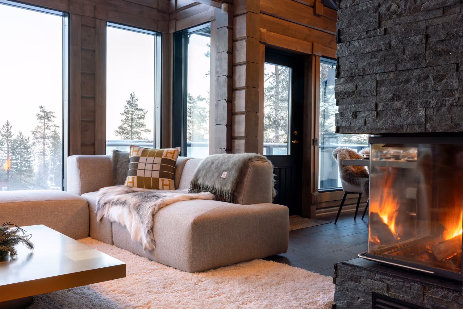 Cosy living room with a contemporary fireplace in a luxury chalet in Lapland.