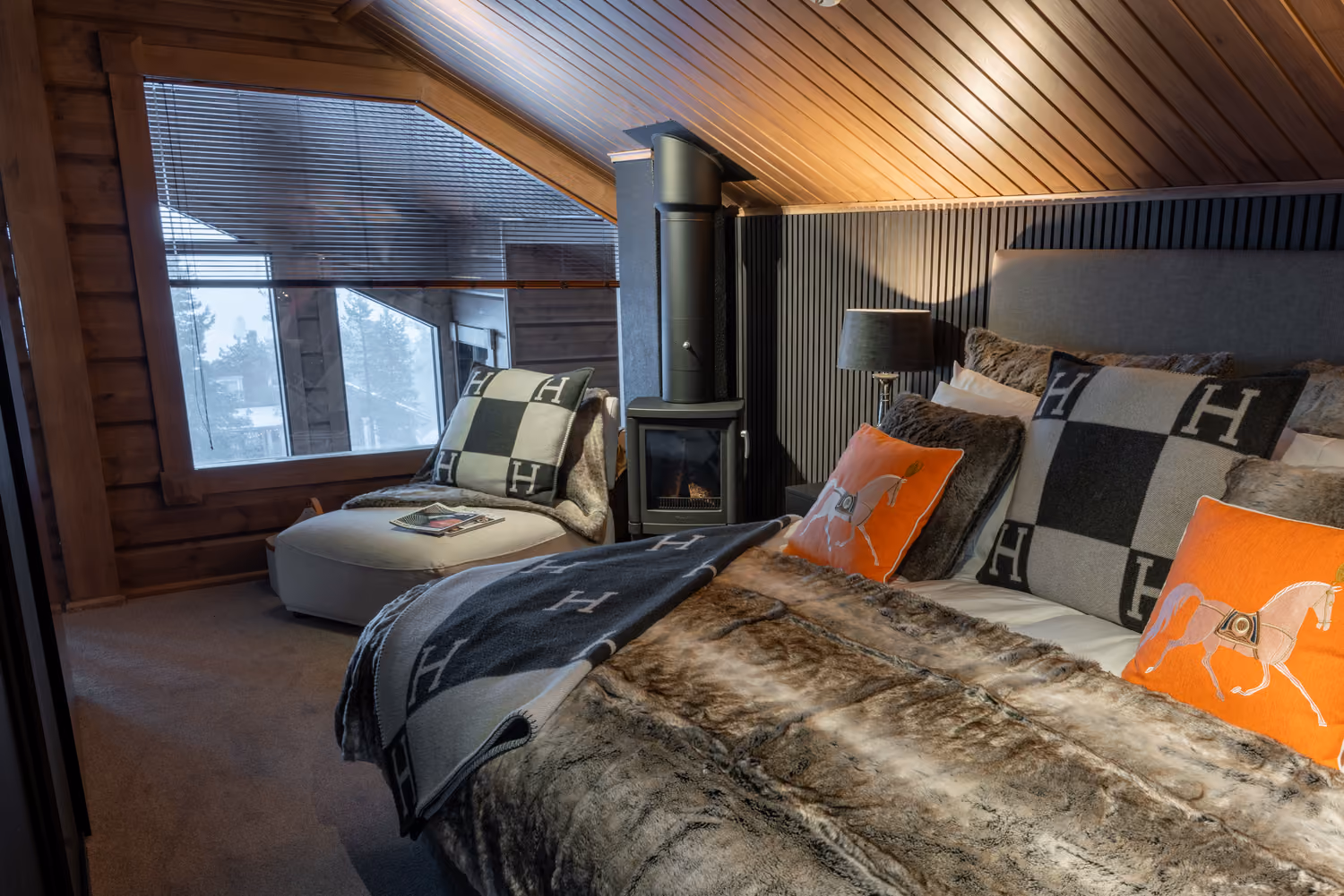 Elegant bedroom with a wood-burning stove in a luxury chalet in Levi.