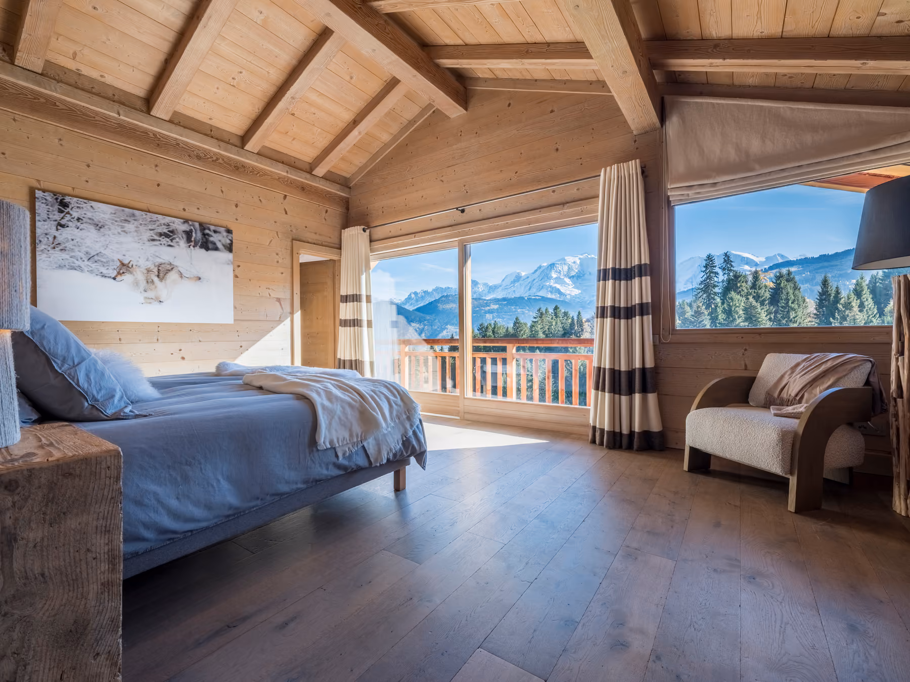Elegant bedroom with a private balcony and panoramic Mont Blanc views in a luxury chalet in Combloux.