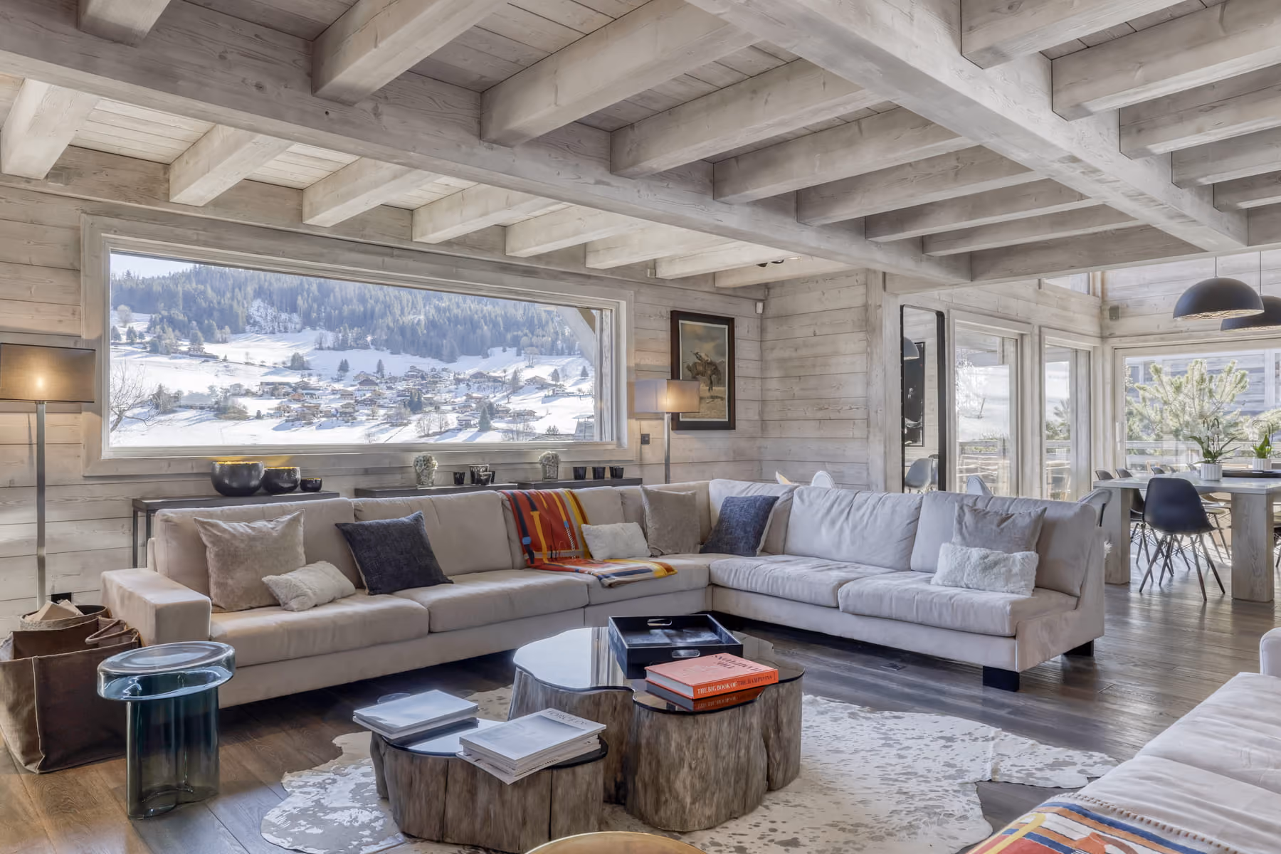 Spacious lounge with oversized sofas and picture windows overlooking the snow-covered mountains.