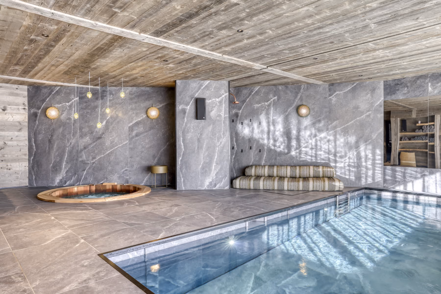 Indoor heated swimming pool with wellness area, bar and Nordic bath in a luxury chalet.