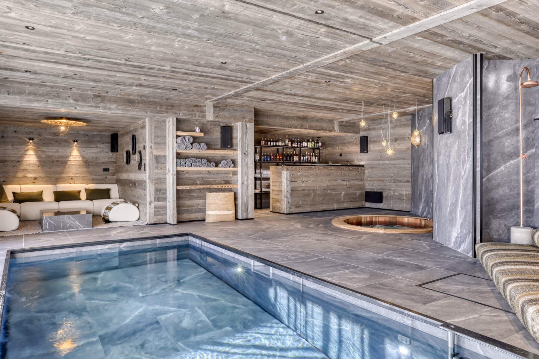 Indoor heated swimming pool with wellness area, bar and Nordic bath in a luxury chalet.