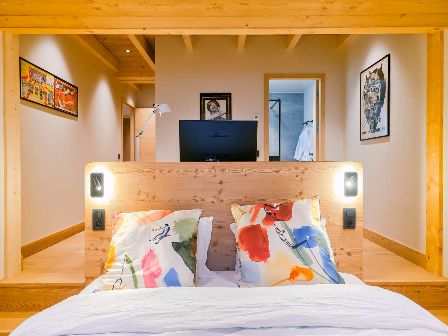 Elegant double bedroom with TV and en-suite bathroom in a luxury mountain chalet.