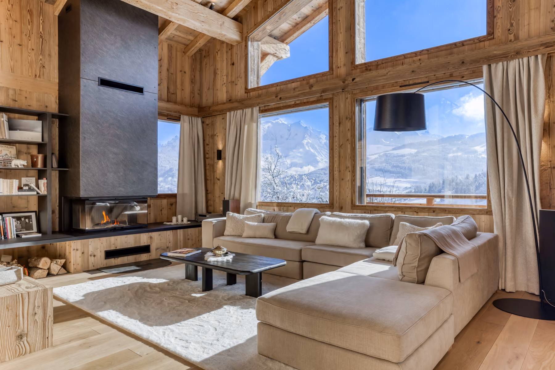 Cathedral-style living room with a designer fireplace and panoramic Mont Blanc views at Chalet Victory in Combloux.