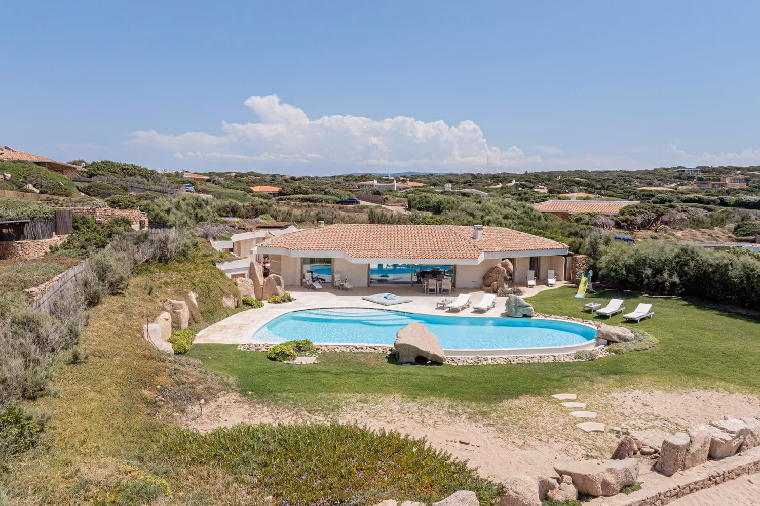 Aerial view of a luxury villa with private pool on the Costa Smeralda coastline.