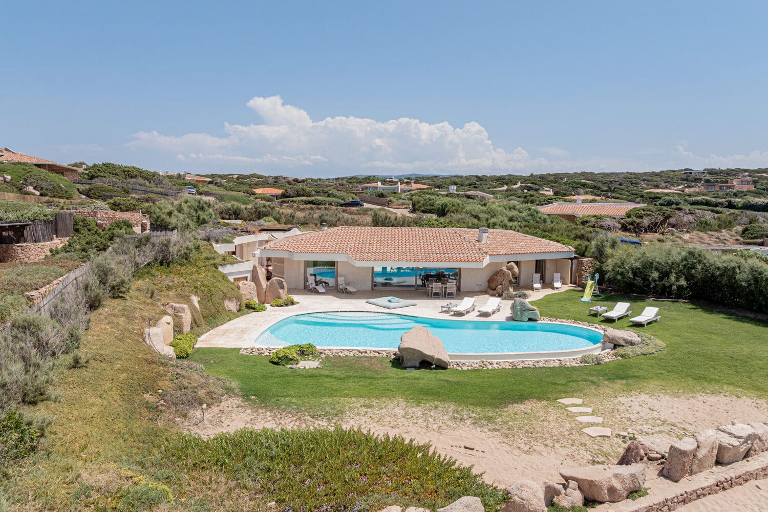 Vue aérienne d'une villa de luxe avec piscine privée en bord de mer sur la Costa Smeralda.