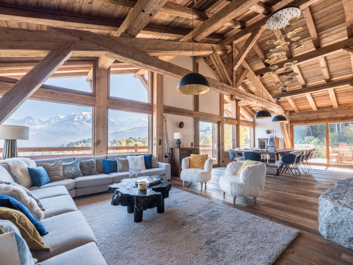 Cathedral-style living room with a fireplace, floor-to-ceiling windows and panoramic Mont Blanc views at Chalet Marianna in Combloux.