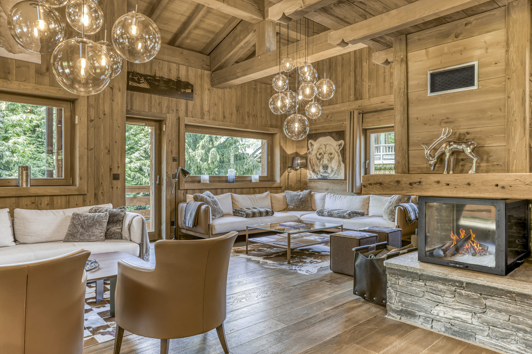 Salon avec cheminée et grande hauteur sous plafond au Chalet des Ours, chalet de prestige à Megève.