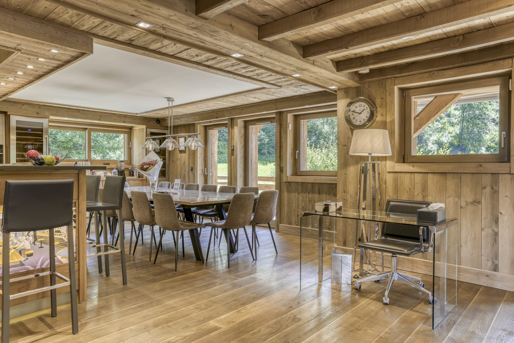 Grande salle à manger conviviale du Chalet des Ours avec cuisine ouverte à Megève.