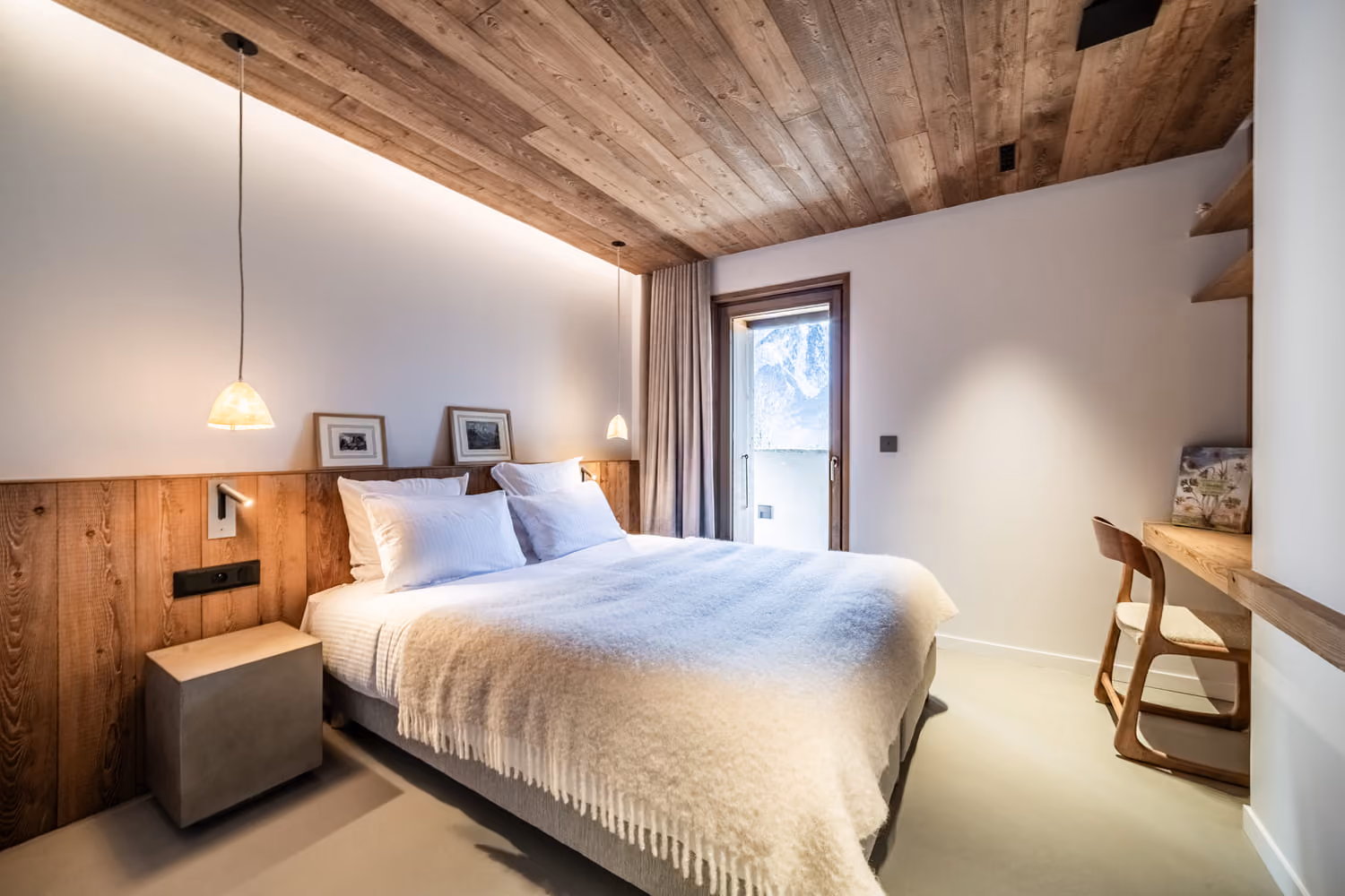 Chambre double contemporaine aux finitions en bois avec bureau et vue sur les montagnes.